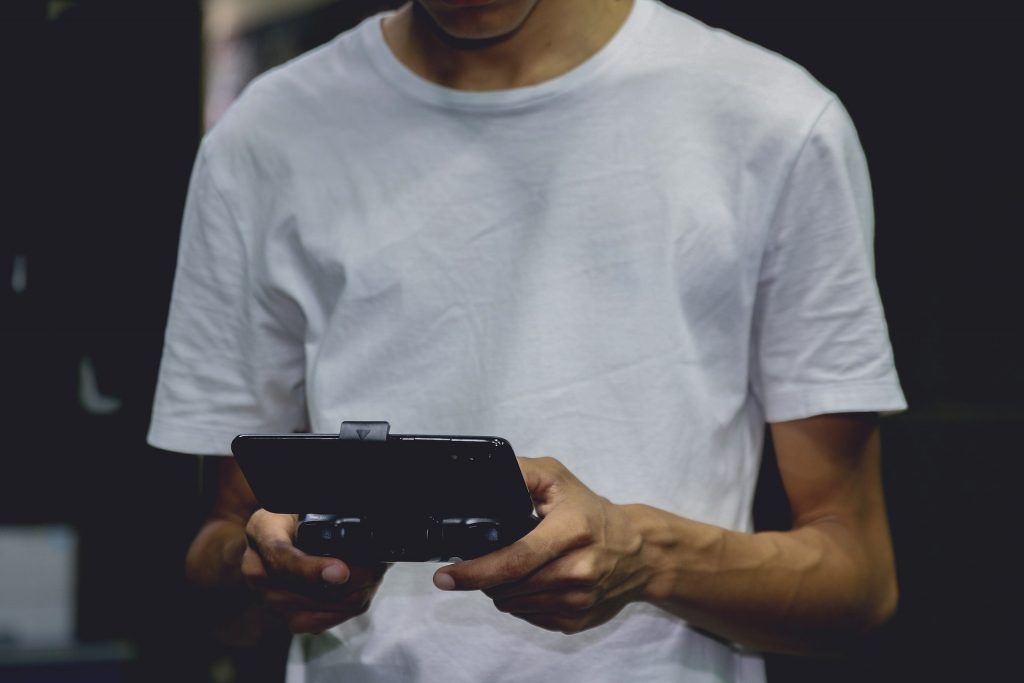 Hombre jugando a los juegos de Instagram con el mando del smartphone.