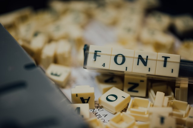 Scrabble letters on a rack spelling the word “FONT.”