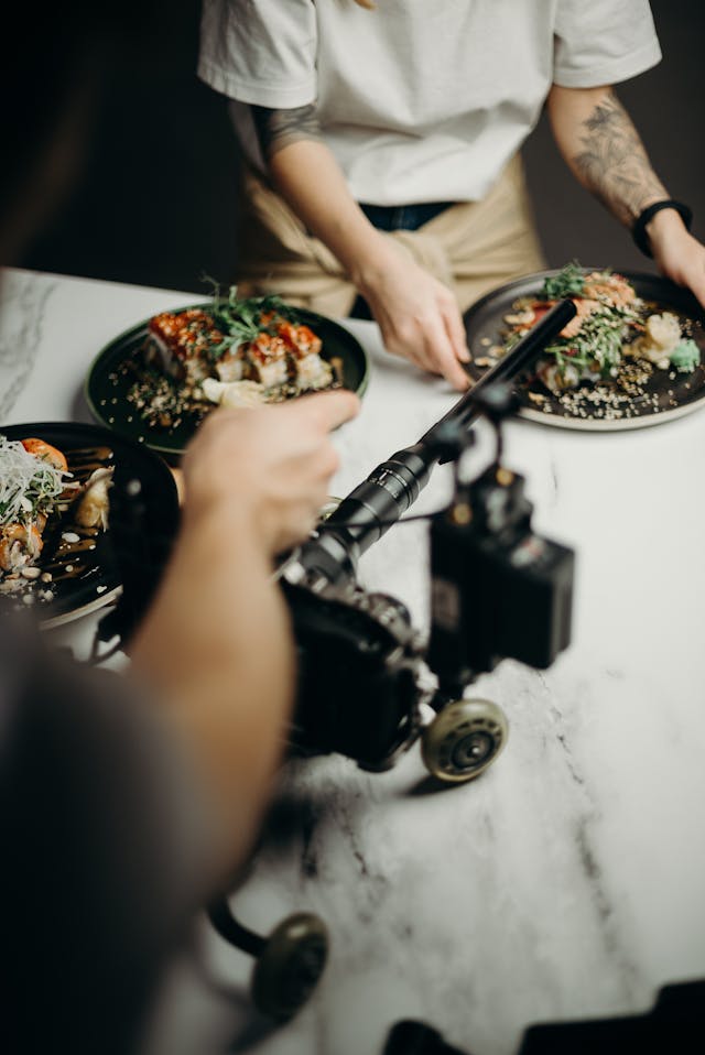 Kameras, die bei einem Fotoshooting auf optisch ansprechende Teller mit Lebensmitteln gerichtet sind.