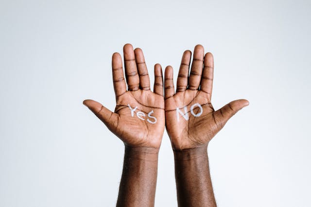 Die Hände einer Person, auf deren eine Handfläche das Wort "Ja" und auf der anderen das Wort "Nein" geschrieben steht.