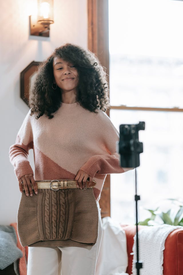 A female influencer filming herself holding up a skirt against her lower body.