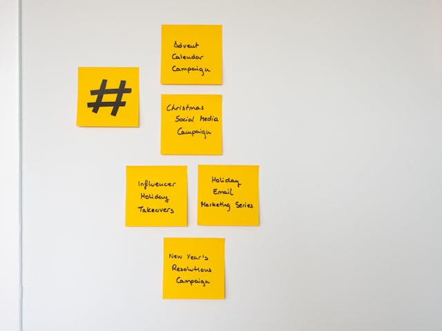 Eine Wand aus gelben Haftnotizen mit Marketingkonzepten, darunter eine mit einem großen Hashtag-Zeichen.