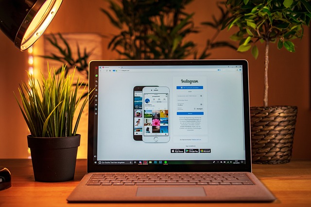 Un escritorio con poca luz con una computadora portátil que muestra la pantalla de inicio de sesión para Instagram.