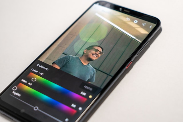 Ein Smartphone, das eine Bearbeitungs-App anzeigt, in der die Farben eines Fotos angepasst werden.