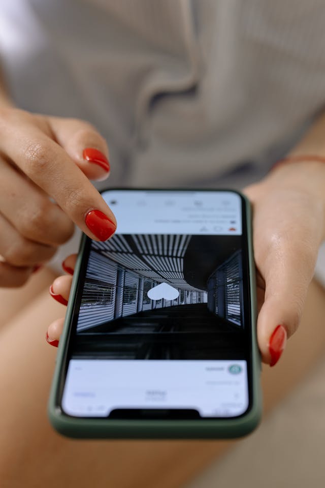 Uma mulher a fazer duplo toque numa publicação Instagram no seu telemóvel para gostar dela.